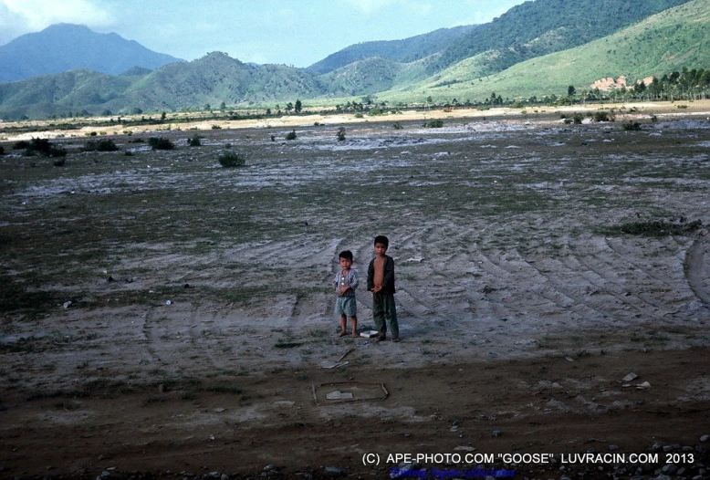 two people stand next to each other on an empty lot