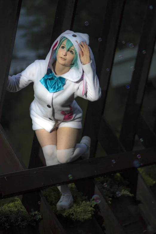 a cosplay girl posing while sitting on some wooden steps