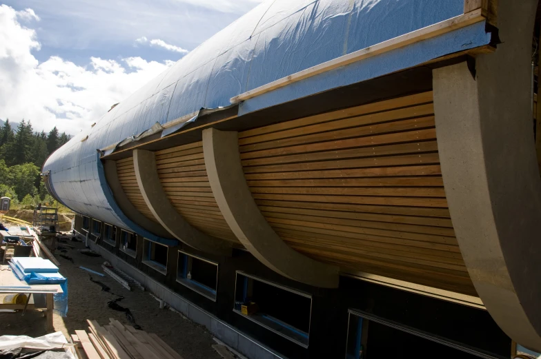 a large wooden boat on a trailer under a cloudy sky