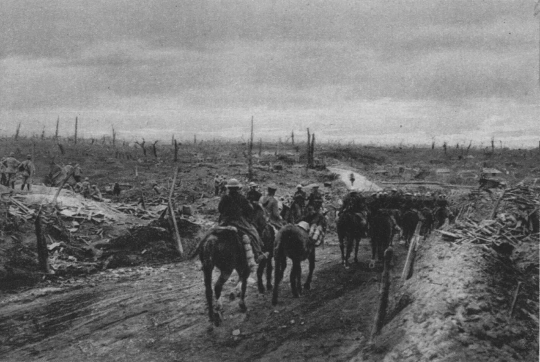 a group of men riding horses down a dirt road