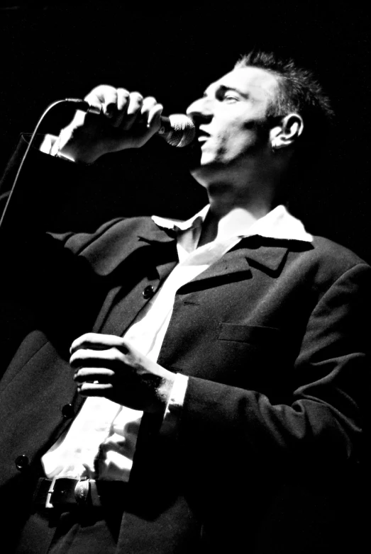 a black and white po of a man singing into a microphone