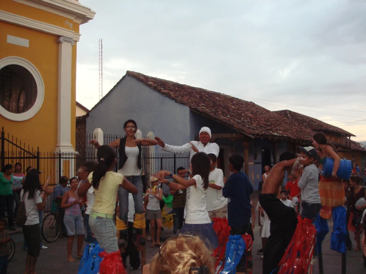 people in a town crowd playing with colorful kites