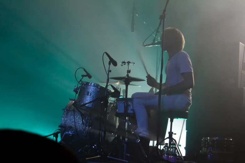 the drums player is on the stage playing with his drum