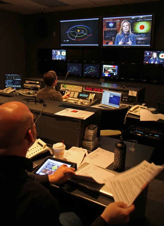 a man is sitting at his desk while watching three monitors