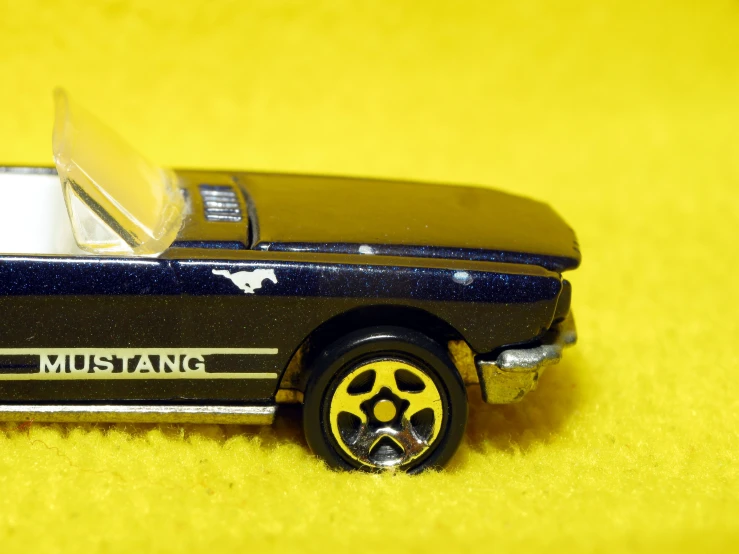 a black toy car on a yellow background