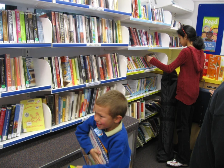 a  looking at some books while an adult looks through