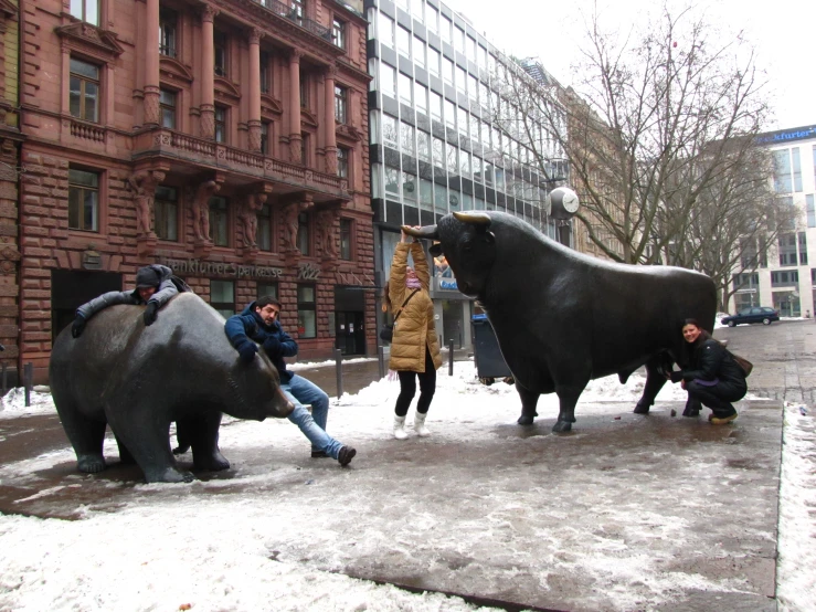 two bull statues on the street, one with his head up