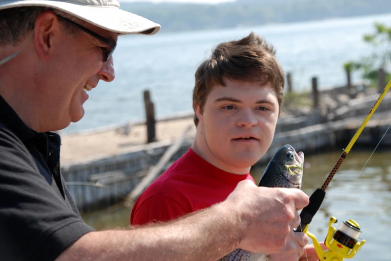 a man is helping his little boy to do a nice fishing trip