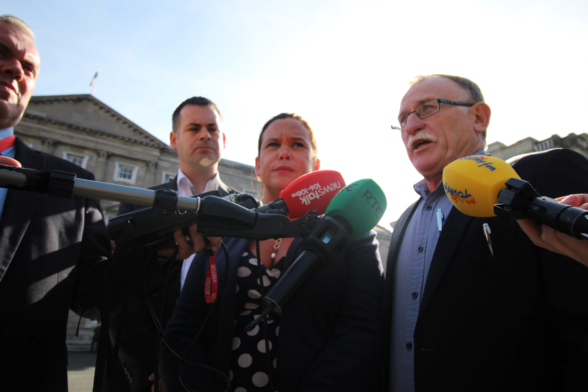 four people standing around talking to reporters about their work