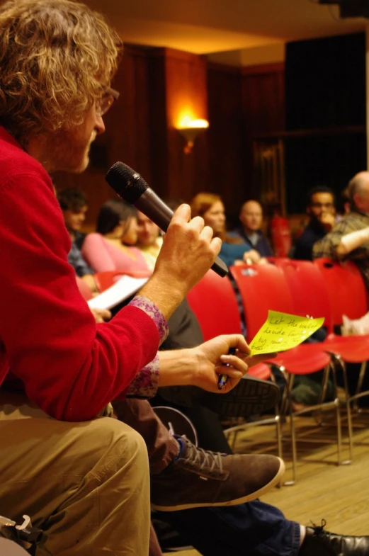 an audience watching a panel of speakers and microphones