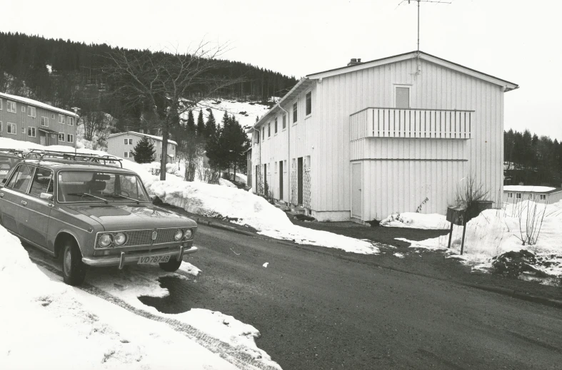 a small brown truck driving down a road next to a building