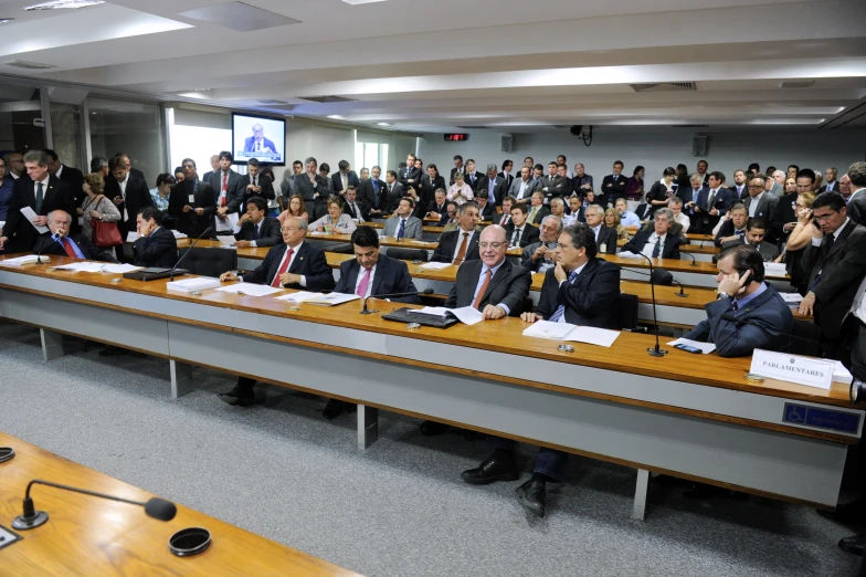 a group of people sit at desks in a room