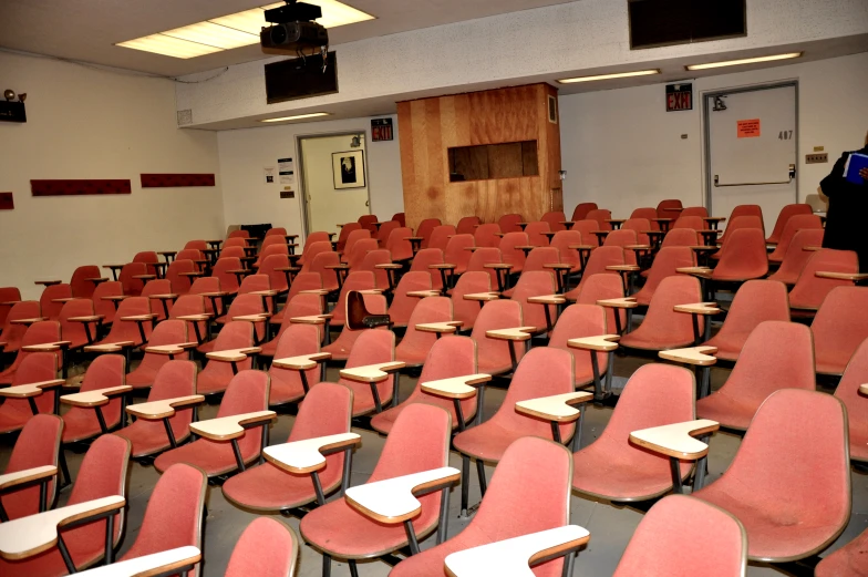 there are several red chairs in this lecture hall