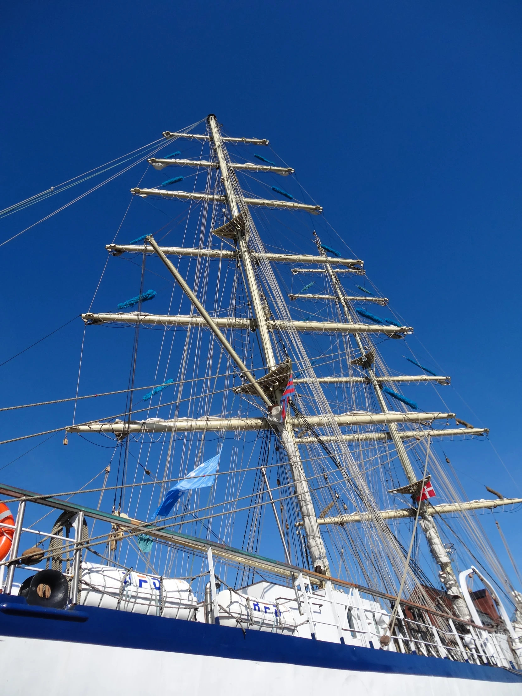 there is a very tall mast of a boat that is docked in the water