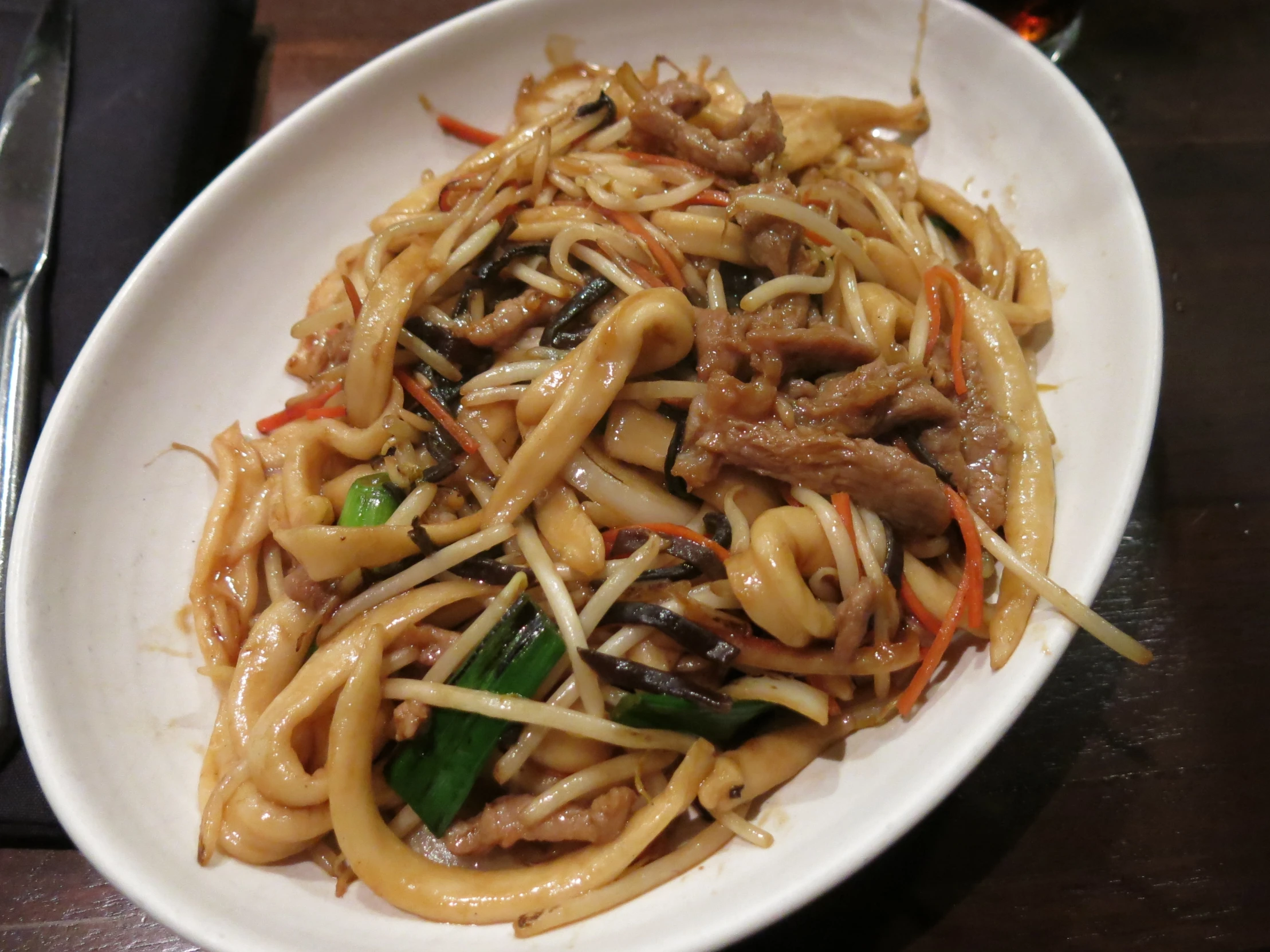 a plate of noodles and vegetables sitting on top of a table