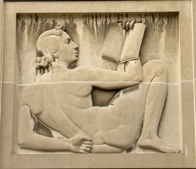 a sculpture of a woman reading a book, sitting down