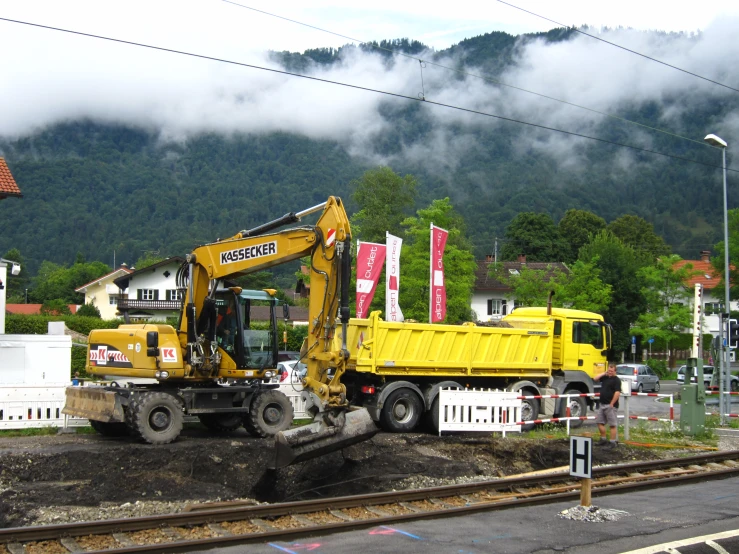 a large construction vehicle being worked on by a dump truck