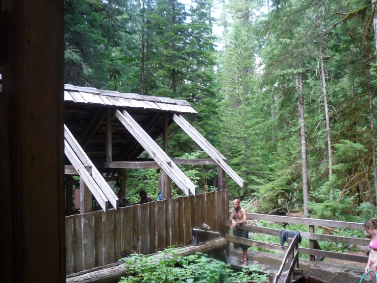 the people walk up to a wooden cabin