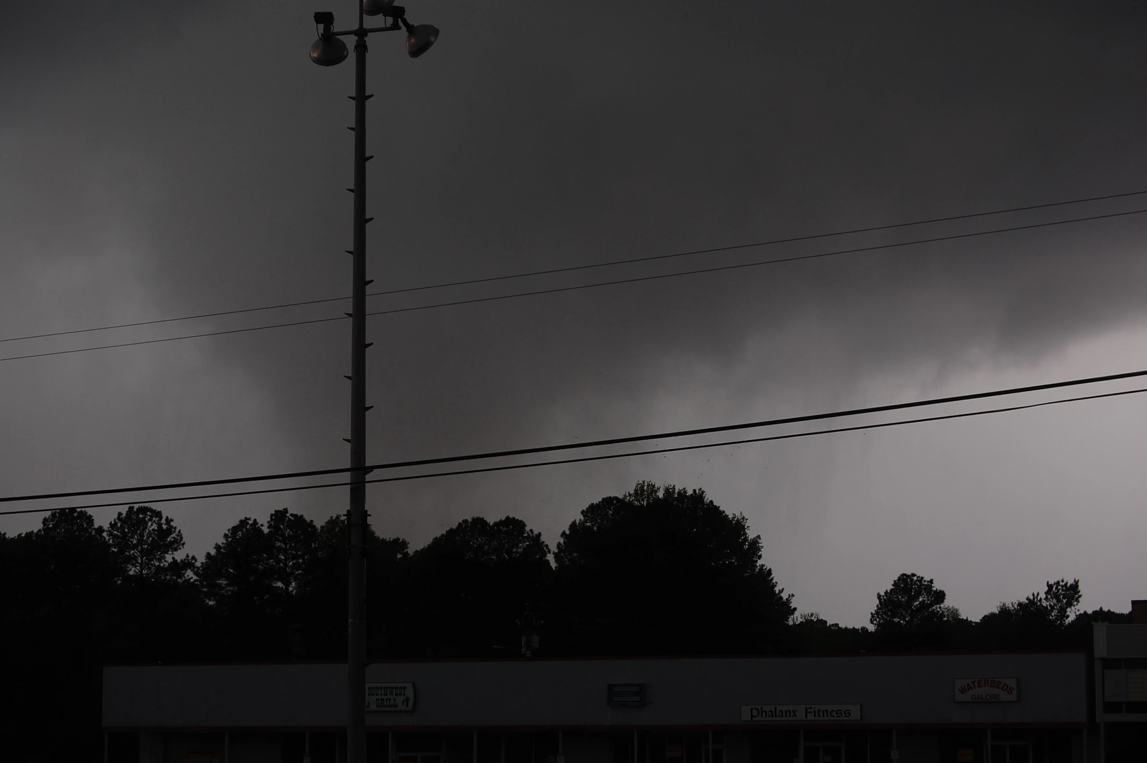 the dark cloud is above a building and power lines