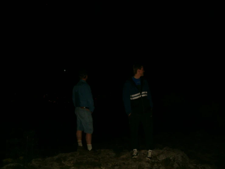 two guys are standing around looking at soing on the ground