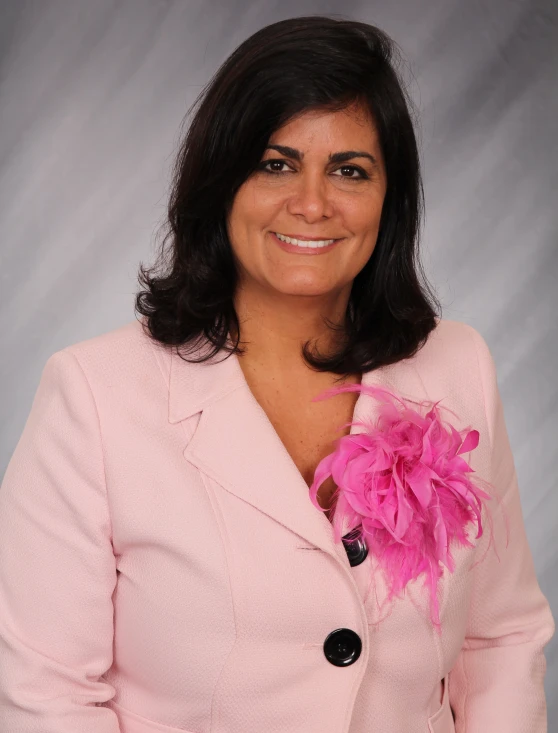 a woman wearing a pink jacket is smiling for the camera