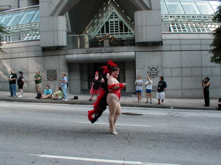 woman in red and black dress walking across street