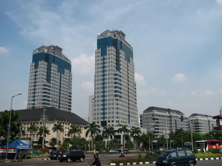 two high rise buildings in front of some parked cars