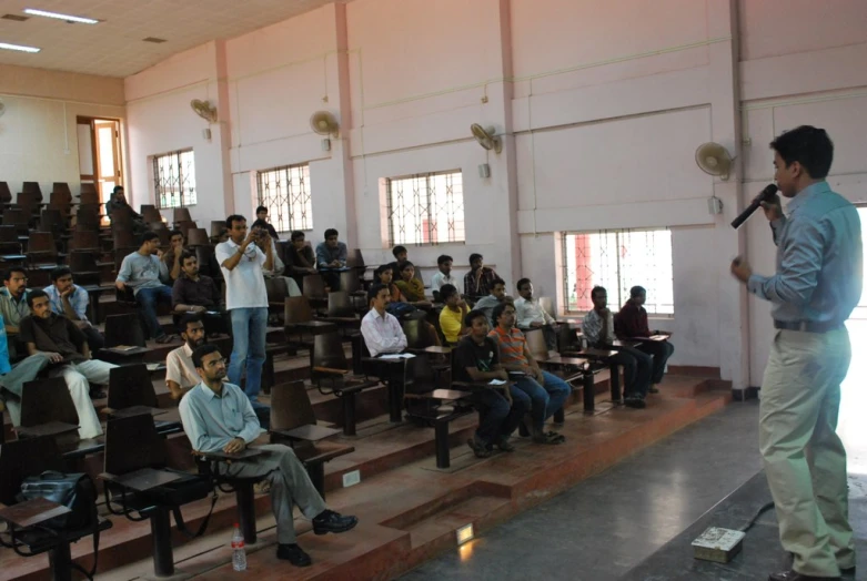 a man is performing a karaoke while many people watch