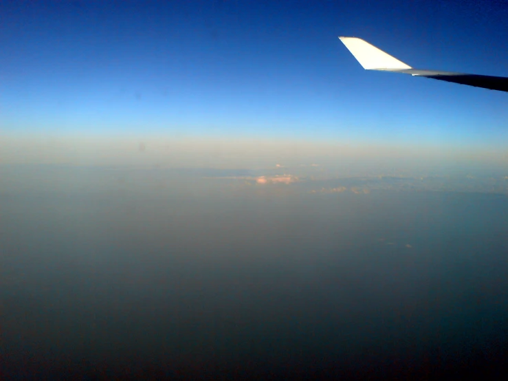 an airplane wing in the sky flying through the sky