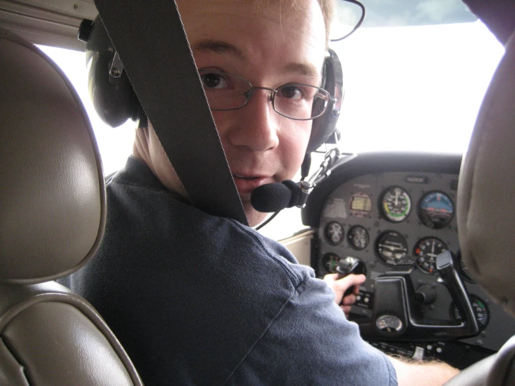 a young man wearing a headset while sitting in a helicopter