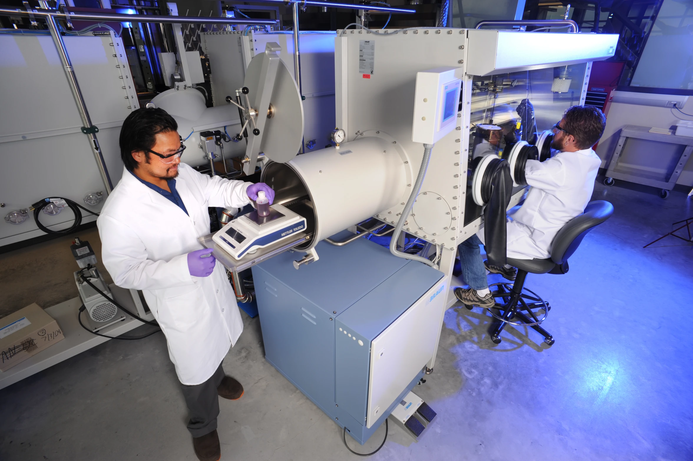 two people working in a laboratory with several apparatuss