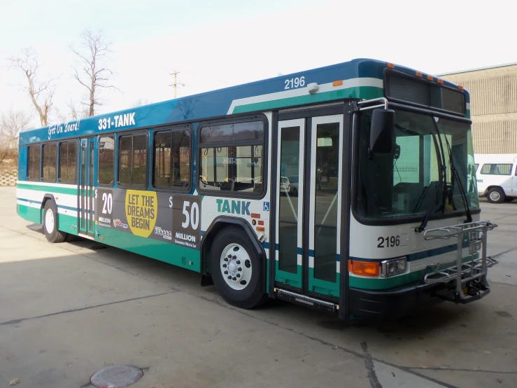 a green and white bus parked on the street