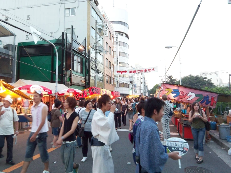 a group of people in the city street with food stands