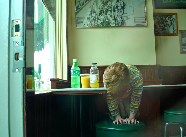 a child on a stool reaching for the lid