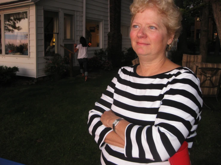 a woman is standing outside of a house