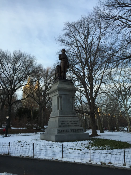 a statue is located in a snowy park