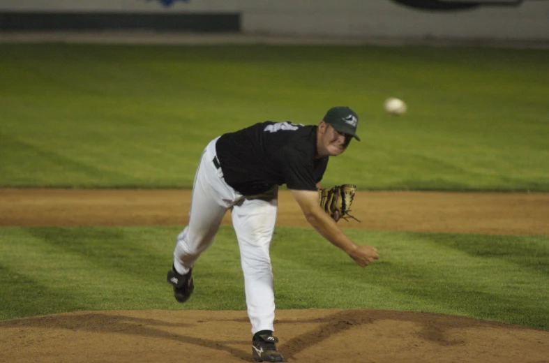 a baseball player throws a ball from the mound