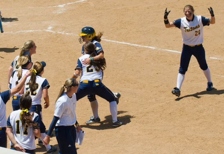 some women playing baseball in uniform on the field