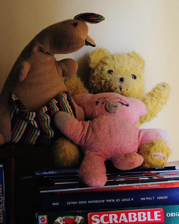 two stuffed animals sitting on top of magazines