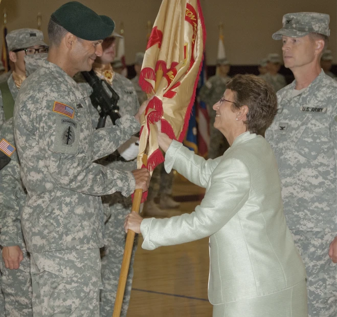 a group of people holding a flag next to a man in uniform