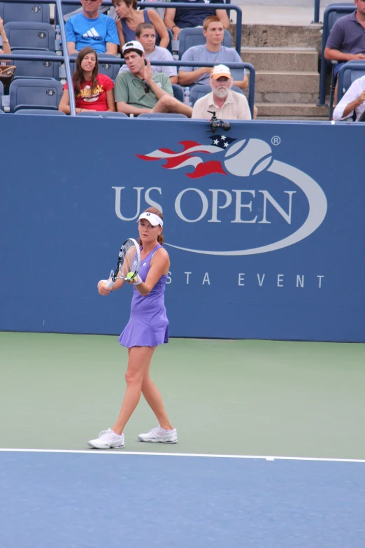 a lady tennis player standing on the court holding a racket
