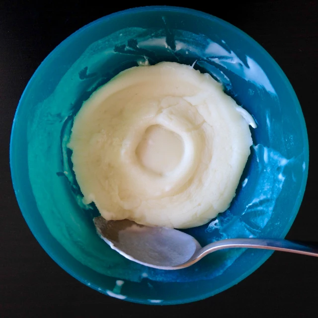 a spoon with mashed potatoes inside of it