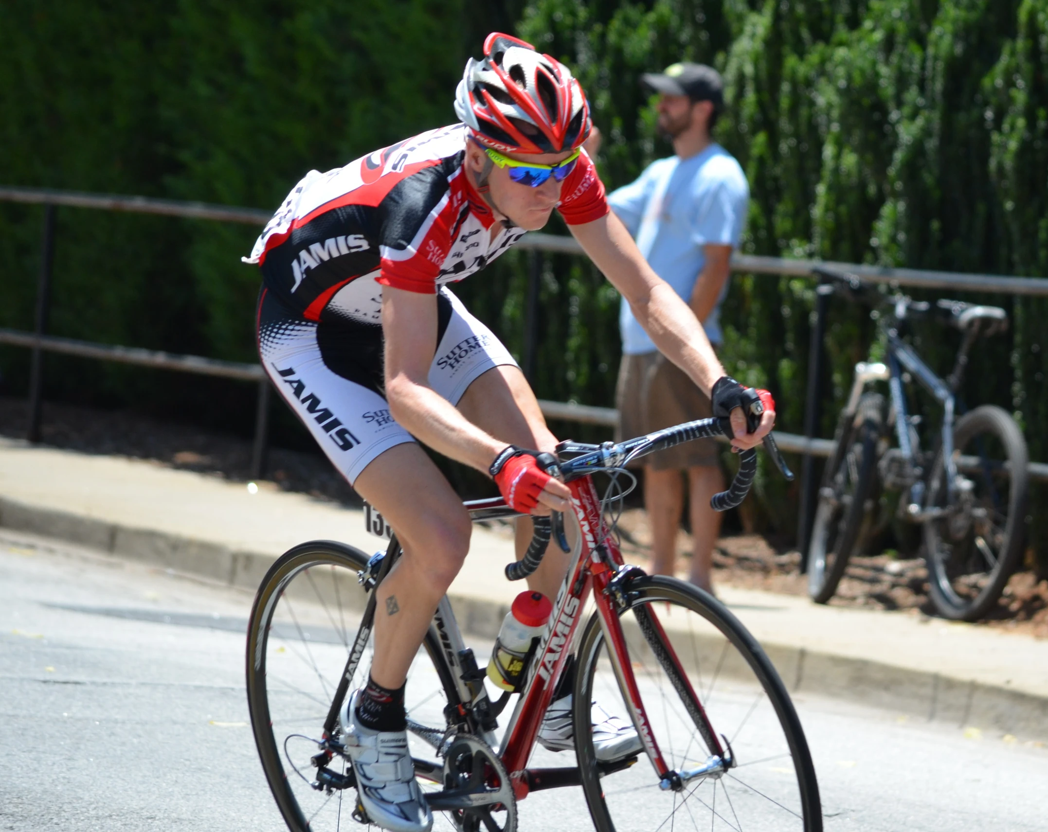 a man in red and white jersey riding a bike