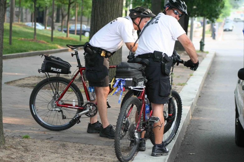 two officers standing next to each other by their bikes