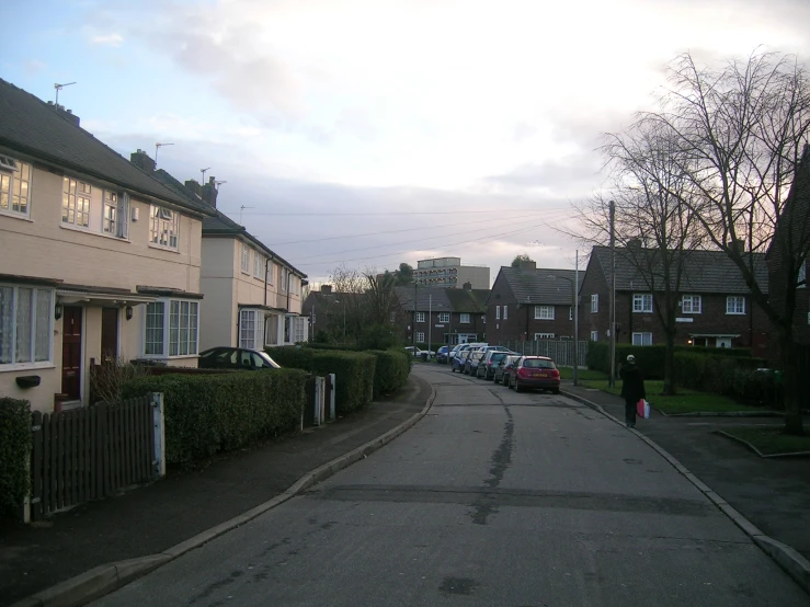 a woman is walking down the street near several houses