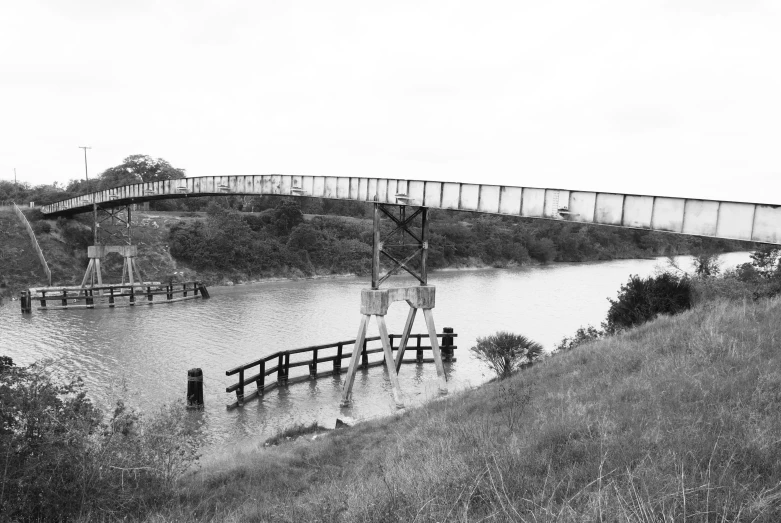 black and white pograph of a bridge spanning a river