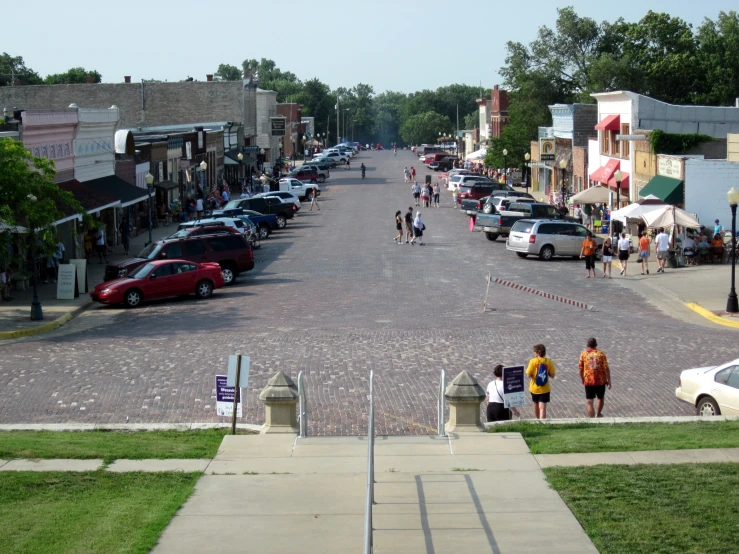 a couple people are walking down the street in front of shops