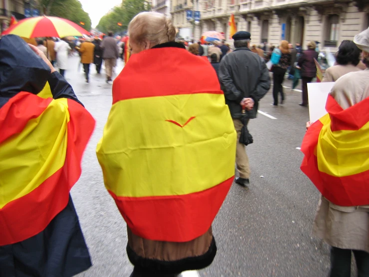 people wearing costumes walking down the street holding umbrellas