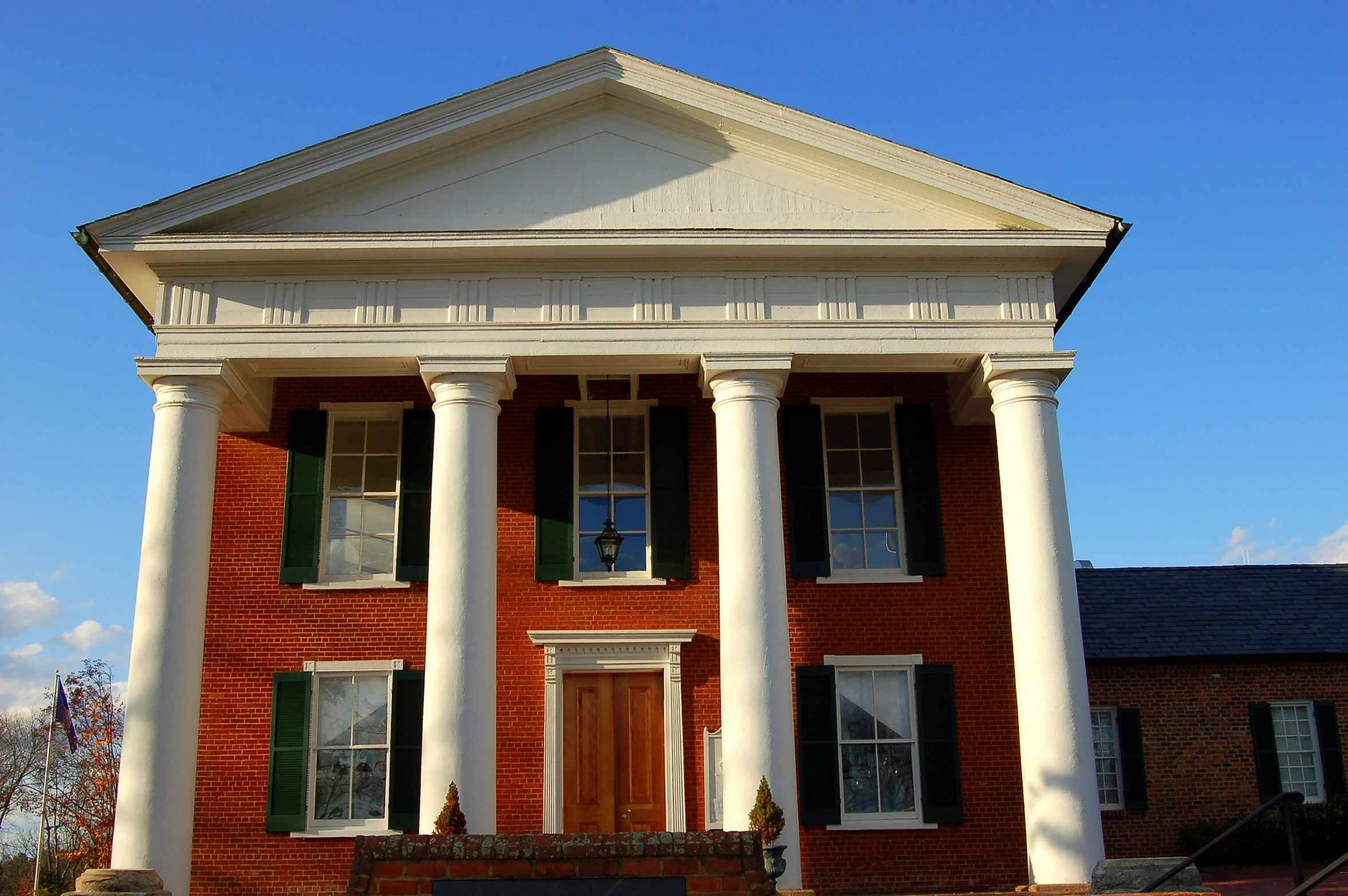 two white pillars on the front of a red brick building