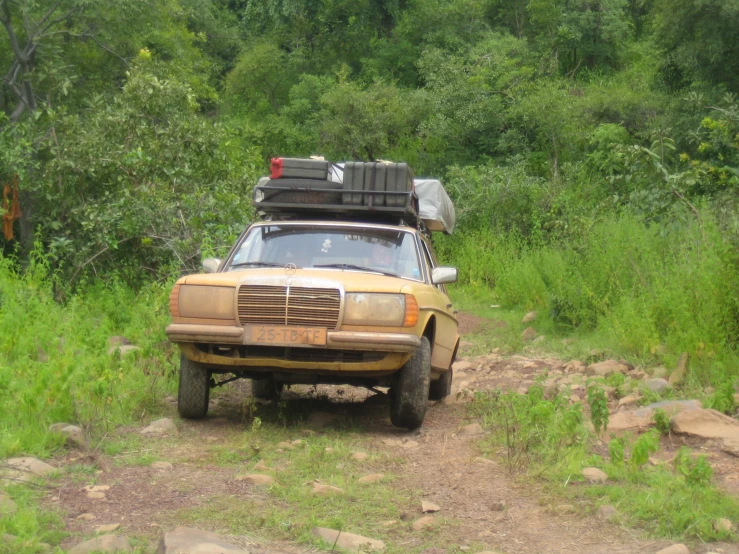 an old yellow van with bags on top of it's head